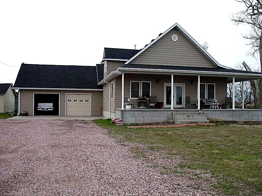 The Reznor farmhouse near Scottsbluff with its finished new roof, wraparound porch and shop building