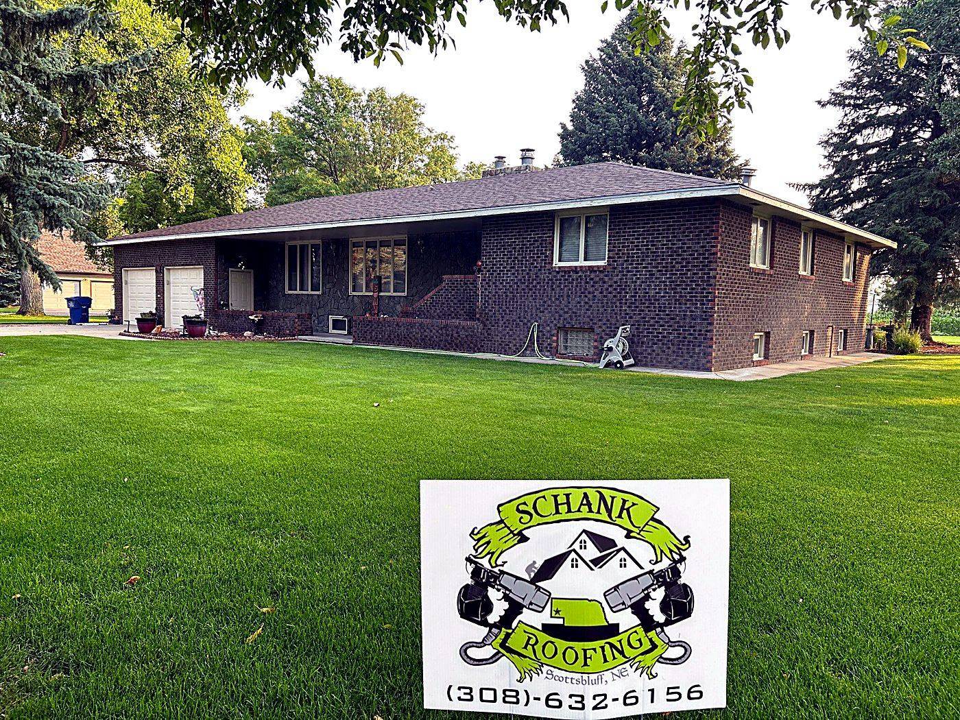 The Strauch residence in Mitchell with its finished roof and a Schank Roofing yard sign