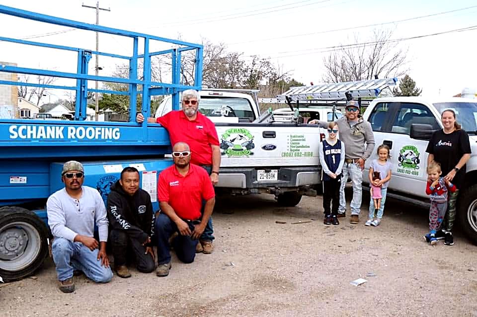 The Schank Roofing crew and their families with the company trucks